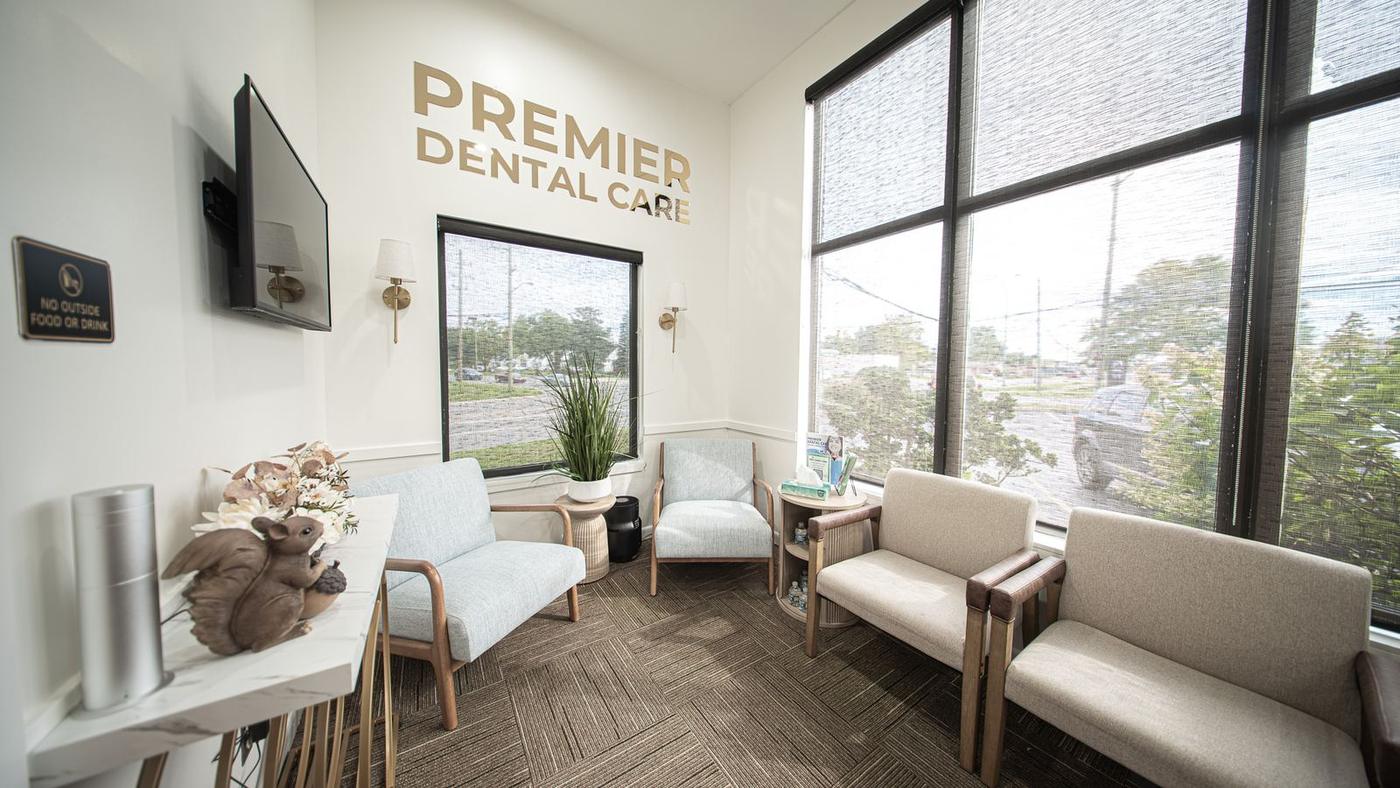 The waiting room at Premier Dental & Implant Center, with upholstered seating and floor-to-ceiling windows